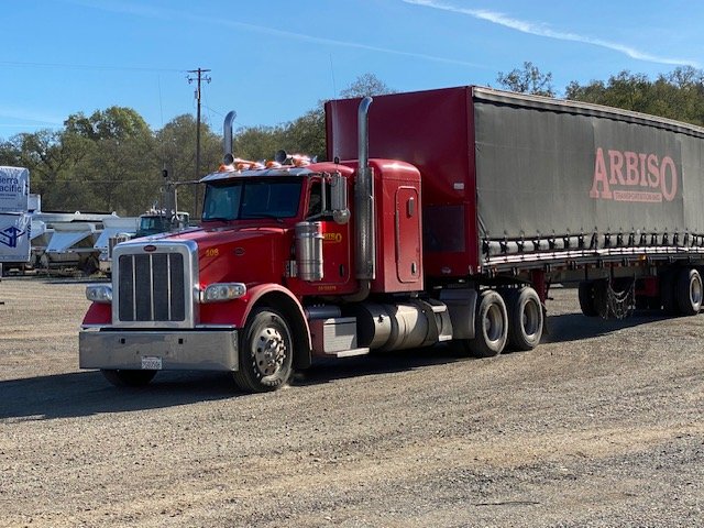 Red Peterbilt with an Arbiso curtain van trailer