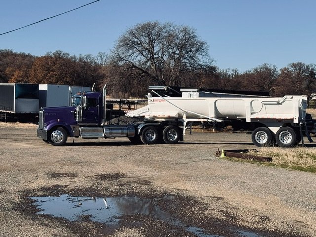 Purple tractor with an end-dump trailer, side view