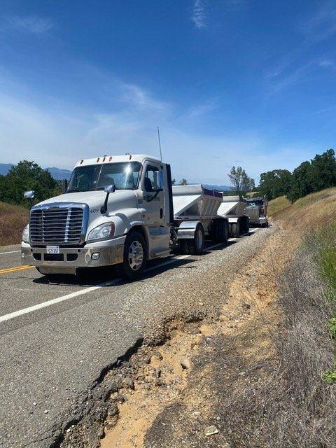 White tractor with trailers on a two-lane road
