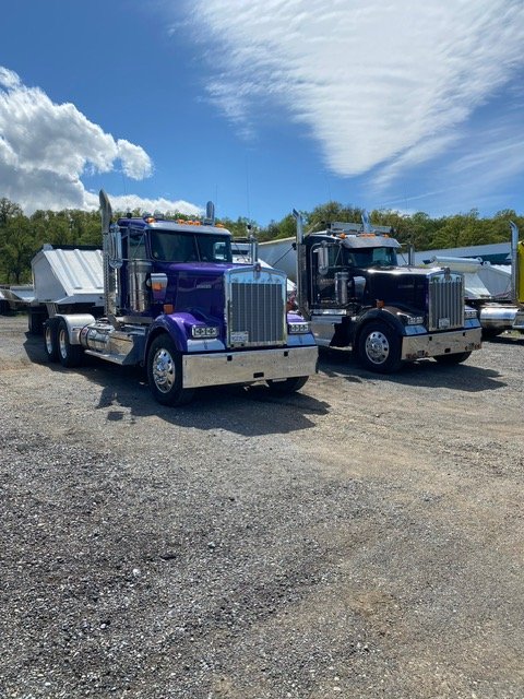 Two purple tractors parked side by side